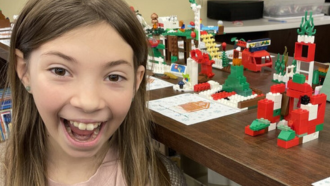 Youth smiling by LEGO display.