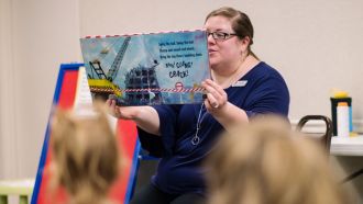 Librarian reads a book to children.