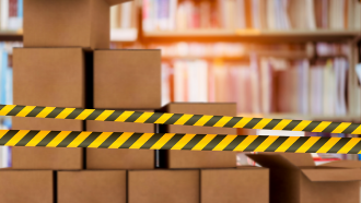caution tape in front of moving boxes in front of bookshelves