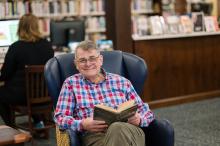 a man happily reads in the library